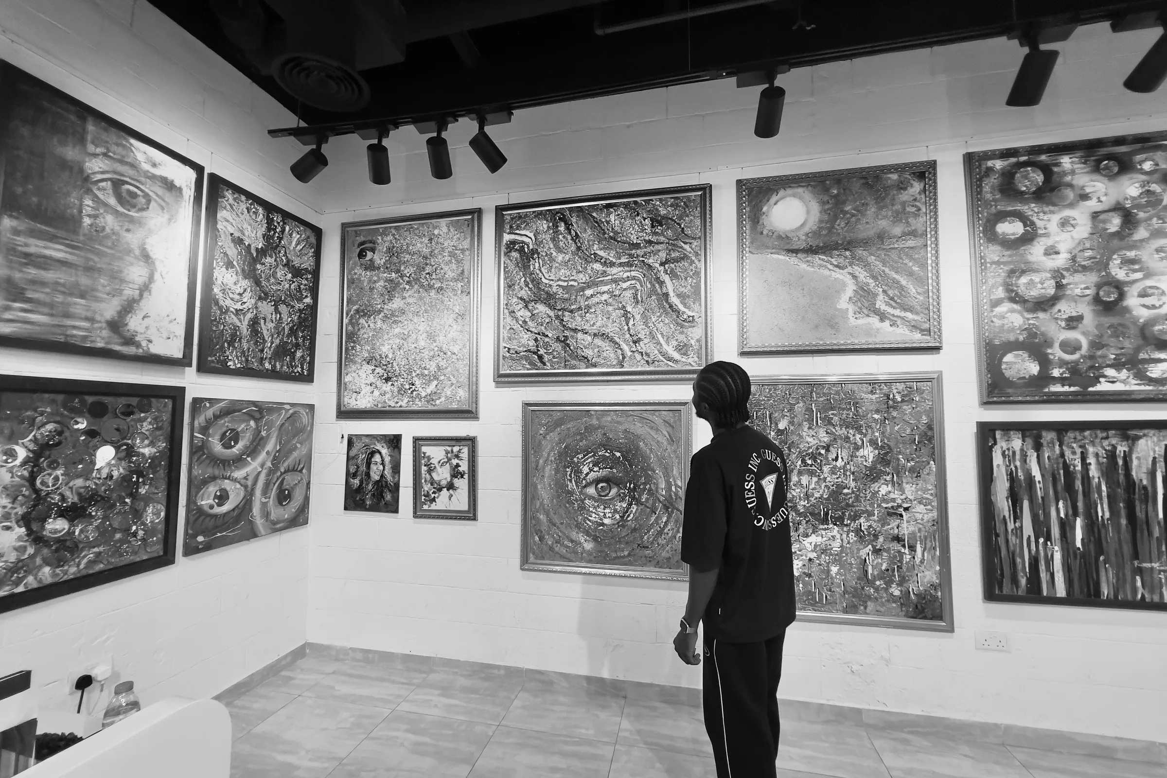 A visitor viewing a wall of paintings at ISOAG Gallery, Al Safa, Dubai